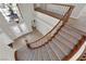 View of curved staircase with wooden handrail and iron balusters, and glass front doors at 2595 Aviv Ct, Las Vegas, NV 89121