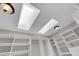 Bright walk-in closet featuring custom built-in shelving, skylights, and overhead lighting at 2595 Aviv Ct, Las Vegas, NV 89121