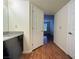 Hallway view to bathroom with vanity, door, and wood-look floors at 2606 S Durango Dr # 171, Las Vegas, NV 89117