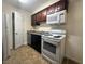 Compact kitchen features white appliances, wood cabinets, and neutral countertops at 2606 S Durango Dr # 171, Las Vegas, NV 89117