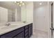Bathroom featuring dual sinks, dark cabinets, large mirror, and tiled floors at 2862 Starling Summit St, Henderson, NV 89044