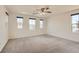 A large carpeted bedroom with multiple windows providing lots of natural light and neighborhood views at 2862 Starling Summit St, Henderson, NV 89044