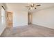 A carpeted bedroom with a ceiling fan and lots of natural light from the windows and an open door at 2862 Starling Summit St, Henderson, NV 89044