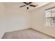 A comfortable bedroom with neutral carpet, ceiling fan, and natural light from a bright window at 2862 Starling Summit St, Henderson, NV 89044