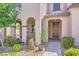 Inviting home entrance with arched porch and lush landscaping leading to the front door at 2862 Starling Summit St, Henderson, NV 89044