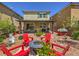 Serene backyard with a fire pit, Adirondack chairs, and covered patio, complemented by lush landscaping and exterior view at 2936 Aragon Terrace Way, Henderson, NV 89044