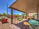 Charming backyard patio featuring covered seating, lush greenery, and a barbecue area, perfect for entertaining at 2936 Aragon Terrace Way, Henderson, NV 89044