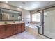 Spacious bathroom has a double vanity, large mirror, separate tub and shower with glass door at 2936 Aragon Terrace Way, Henderson, NV 89044