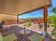 Relaxing covered patio with string lights, colorful seating, and a well-manicured garden, perfect for outdoor enjoyment at 2936 Aragon Terrace Way, Henderson, NV 89044