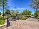 Landscaped walkway featuring a colorful brick pathway, benches, and lush greenery at 2936 Aragon Terrace Way, Henderson, NV 89044