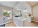 Bright, modern kitchen with white cabinets, island cooktop, and stainless steel appliances, open to the dining area at 3012 Haddon Dr, Las Vegas, NV 89134
