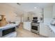 Modern kitchen featuring stainless steel appliances, white cabinetry, and seamless transition to the living and dining areas at 3012 Haddon Dr, Las Vegas, NV 89134