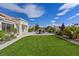 Spacious backyard boasts artificial grass, a patio with seating, and well-maintained landscaping for outdoor living at 3024 Lotus Hill Dr, Las Vegas, NV 89134