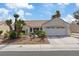 Attractive home exterior featuring a well-manicured lawn, desert landscaping, and a two-car garage at 3024 Lotus Hill Dr, Las Vegas, NV 89134