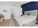 Bright bedroom featuring hardwood floors, a blue accent wall, and a cozy bed at 3024 Lotus Hill Dr, Las Vegas, NV 89134