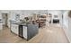 Modern open-concept space featuring a kitchen island with a wine cooler, dining area, and living room at 3024 Lotus Hill Dr, Las Vegas, NV 89134