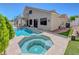 An inviting backyard featuring a private pool, jacuzzi, and a charming second-story balcony with spiral staircase at 3079 Evening Mist Ave, Henderson, NV 89052