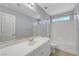 Bright bathroom featuring a tub and shower combination with a vanity and large mirror at 3079 Evening Mist Ave, Henderson, NV 89052