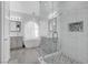 Modern bathroom with a glass-enclosed shower, dual sinks, and a soaking tub under an arched window at 3079 Evening Mist Ave, Henderson, NV 89052