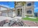 Inviting front entrance with drought-resistant landscaping and a three-car garage at 3079 Evening Mist Ave, Henderson, NV 89052