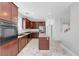 Modern kitchen with a center island, stainless steel appliances, dark wood cabinets, and marble floors at 3079 Evening Mist Ave, Henderson, NV 89052
