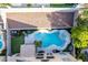 Aerial view of a private backyard with a unique pool, spa, lush greenery, and outdoor kitchen at 3079 Paseo Mountain Ave, Henderson, NV 89052