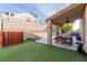 Spacious backyard with artificial grass, a putting green, patio, and retaining wall at 3079 Paseo Mountain Ave, Henderson, NV 89052