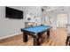 Open game room featuring a fireplace, pool table, bar seating, and wood flooring at 3079 Paseo Mountain Ave, Henderson, NV 89052