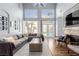 Bright living room featuring a gray sectional sofa, high ceilings, and a fireplace with a stone surround at 3079 Paseo Mountain Ave, Henderson, NV 89052