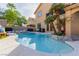 Back exterior showing a large pool with attached spa, well manicured plants, and tall palm trees at 3079 Paseo Mountain Ave, Henderson, NV 89052