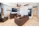 Cozy living room featuring a modern TV, comfortable sofa, and neutral tile flooring at 3112 Twining Ave, North Las Vegas, NV 89030