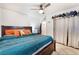 Comfortable main bedroom featuring a ceiling fan, bedside table, and white curtains for added privacy at 3112 Twining Ave, North Las Vegas, NV 89030