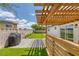 Landscaped backyard featuring a pergola, artificial turf, and paved patio at 325 Heather Dr, Henderson, NV 89002