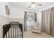Cozy Bedroom features a black crib, beige glider, and natural light at 325 Heather Dr, Henderson, NV 89002