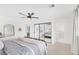 Spacious bedroom with neutral decor, ceiling fan, mirrored closet doors, and access to ensuite bathroom at 325 Heather Dr, Henderson, NV 89002