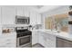 Modern kitchen featuring stainless steel appliances, white countertops, and a farmhouse sink at 325 Heather Dr, Henderson, NV 89002