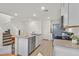 Well-lit kitchen with stainless steel appliances, a center island with seating, and hardwood floors with stairs adjacent at 3762 Sonrisa Vista Ave, Henderson, NV 89044