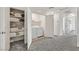Carpeted laundry room with a washer and dryer, storage shelves and white trim at 3762 Sonrisa Vista Ave, Henderson, NV 89044