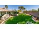Well-maintained backyard with manicured lawn, mature palm trees, and ample space for outdoor activities at 4004 Nancy Margarite Ln, Las Vegas, NV 89130