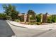An elegant community entrance with stone signage, attractive landscaping, and curved concrete sidewalks at 4004 Nancy Margarite Ln, Las Vegas, NV 89130