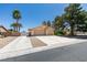 Single-story home featuring a two-car garage, palm trees, mature shade trees and gravel landscaping at 4004 Nancy Margarite Ln, Las Vegas, NV 89130