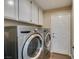 A laundry room with a front load washer and dryer and cabinets at 4004 Nancy Margarite Ln, Las Vegas, NV 89130