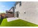 Exterior shot of backyard with synthetic grass, block wall and sliding glass door entry at 4517 Swimming Minnow Ave, Las Vegas, NV 89141