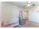 Bright bedroom with crib, comfortable chair, and neutral decor at 4517 Swimming Minnow Ave, Las Vegas, NV 89141