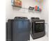 Modern laundry room featuring gray front-load washer and dryer with storage shelf above at 4517 Swimming Minnow Ave, Las Vegas, NV 89141
