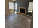 Bright living room featuring wood floors, a cozy fireplace, and large windows for natural light at 4720 Krissylouise Way, Las Vegas, NV 89121