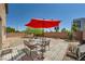 Spacious backyard with stone pavers, outdoor furniture and a red patio umbrella at 4902 Guysborough St, Las Vegas, NV 89148