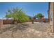 Spacious backyard with gravel, mature tree, brick wall, patio, and seating area at 4902 Guysborough St, Las Vegas, NV 89148