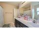 Bathroom featuring double vanity, large mirror, and shower-tub combo with patterned curtain at 4902 Guysborough St, Las Vegas, NV 89148