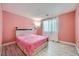 Cozy bedroom featuring a bed with a pink cover, wood floors, and bright pink walls at 4902 Guysborough St, Las Vegas, NV 89148